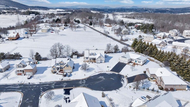 snowy aerial view with a mountain view and a residential view