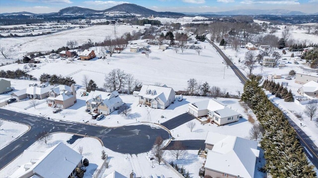 snowy aerial view with a residential view and a mountain view