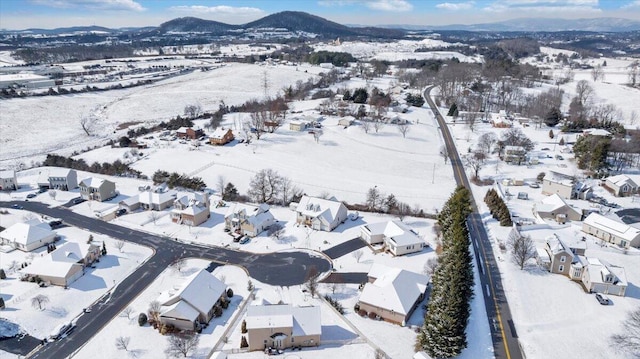 snowy aerial view featuring a residential view and a mountain view