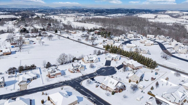 snowy aerial view featuring a residential view and a mountain view