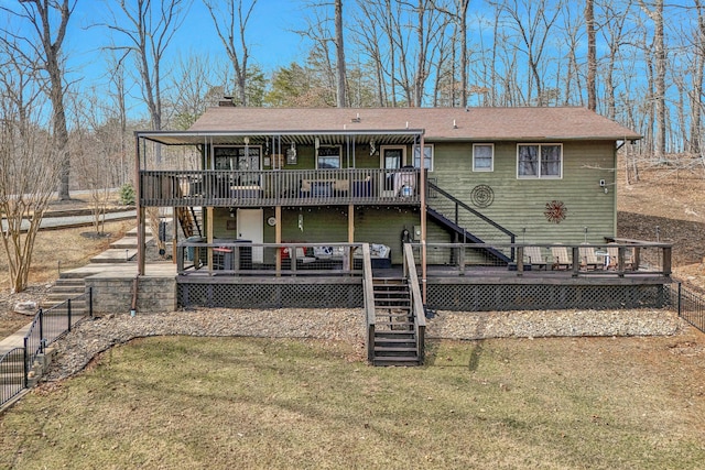 rear view of house featuring a chimney, stairway, a lawn, and a wooden deck