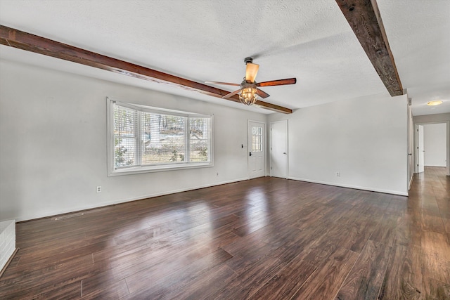 unfurnished living room with wood finished floors, beamed ceiling, baseboards, a textured ceiling, and ceiling fan