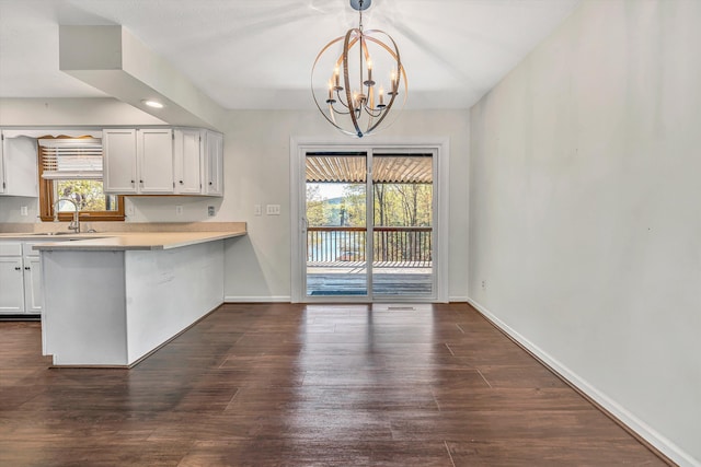 kitchen featuring white cabinets, a notable chandelier, a sink, and light countertops