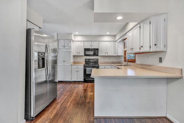 kitchen featuring a peninsula, dark wood-style floors, a sink, light countertops, and black appliances