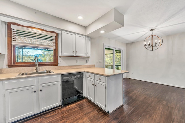 kitchen with a peninsula, light countertops, a sink, an inviting chandelier, and dishwasher