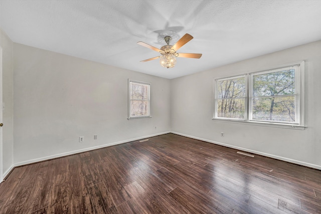 empty room with visible vents, baseboards, a ceiling fan, and wood finished floors