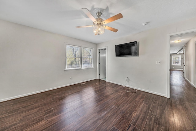 empty room with ceiling fan, baseboards, and wood finished floors