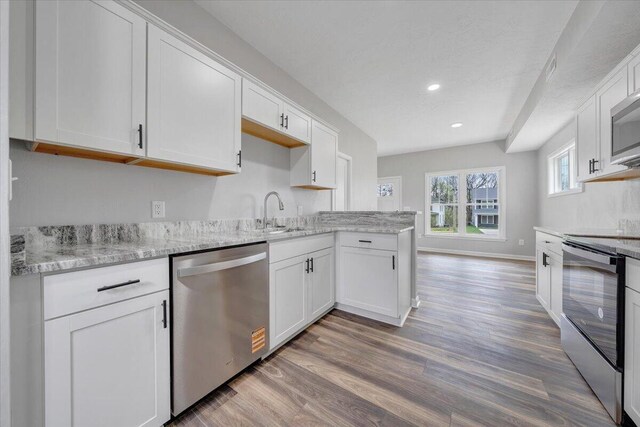 2236 Kenwood Blvd SE, Roanoke, VA 24013 - kitchen with appliances with stainless steel finishes, a sink, light wood-style floors, white cabinets, and recessed lighting