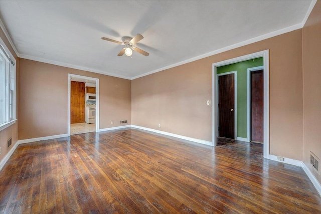 spare room featuring dark wood-style floors, crown molding, ceiling fan, and baseboards