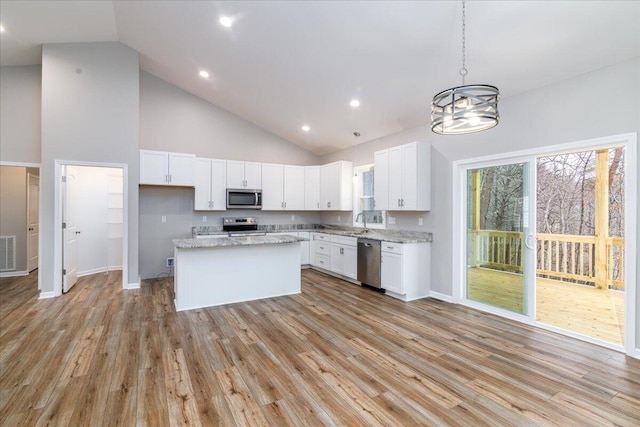 kitchen featuring white cabinets, light wood-style floors, high vaulted ceiling, stainless steel appliances, and visible vents