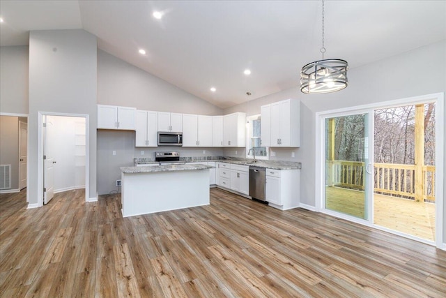 kitchen with appliances with stainless steel finishes, white cabinets, plenty of natural light, and light wood-style flooring