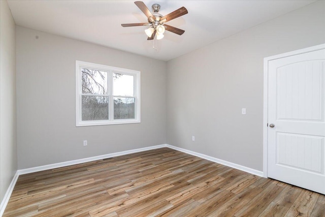empty room featuring light wood-style floors, baseboards, and ceiling fan