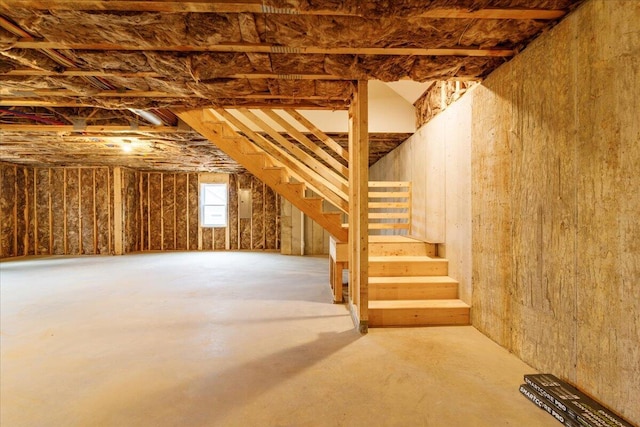below grade area with electric panel and stairs