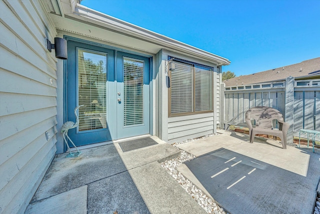 entrance to property featuring a patio area and fence