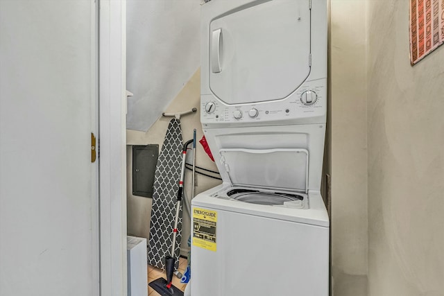 laundry area featuring laundry area, stacked washer and dryer, and wood finished floors