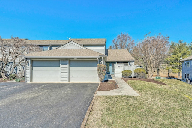 view of property with fence, a shingled roof, a front lawn, a garage, and aphalt driveway