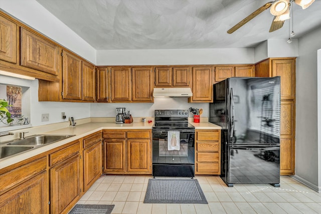 kitchen with under cabinet range hood, black appliances, brown cabinetry, and light countertops