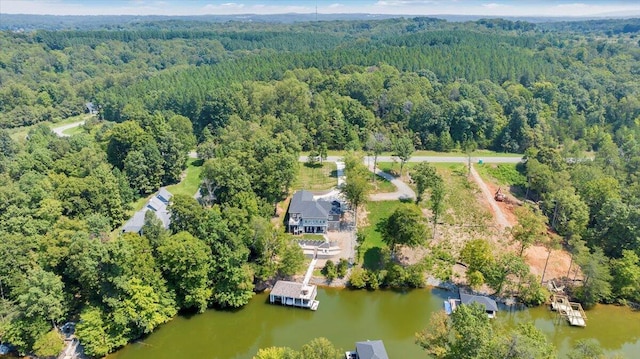 birds eye view of property featuring a water view and a wooded view