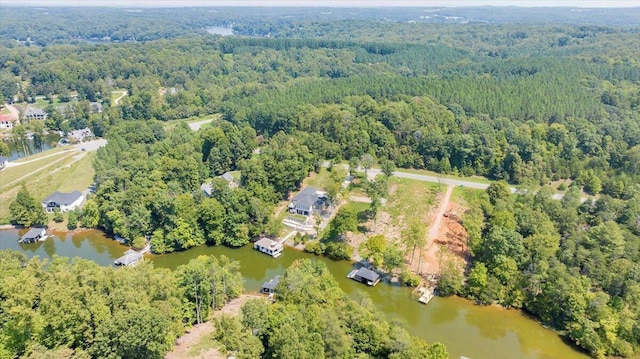 birds eye view of property featuring a water view and a view of trees