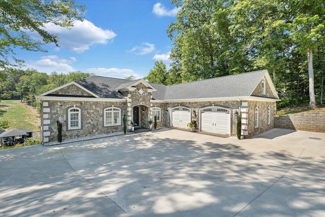 view of front facade with concrete driveway, roof with shingles, and an attached garage