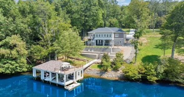 drone / aerial view featuring a water view and a wooded view