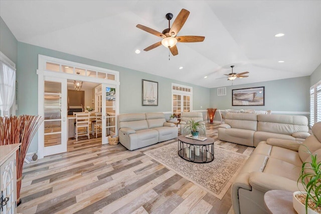 living room featuring vaulted ceiling, light wood-type flooring, visible vents, and recessed lighting