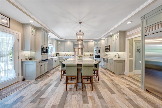 kitchen featuring appliances with stainless steel finishes, hanging light fixtures, and gray cabinetry