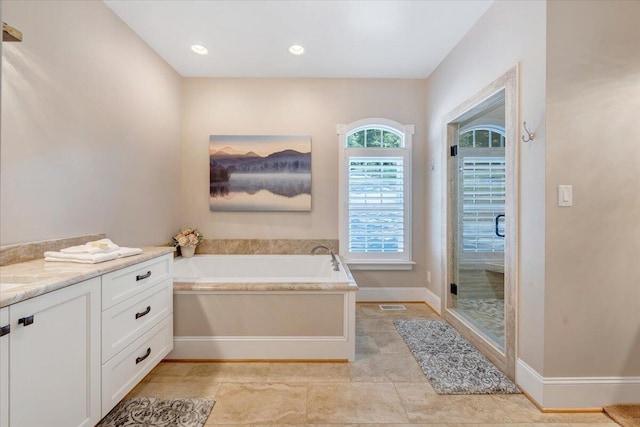 bathroom with visible vents, baseboards, a garden tub, vanity, and a shower stall