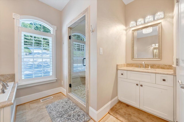 bathroom featuring a stall shower, vanity, visible vents, and baseboards