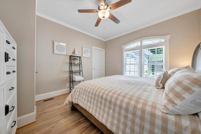 bedroom featuring light wood-style floors, baseboards, visible vents, and crown molding