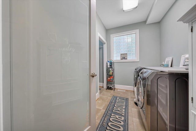 washroom featuring washer and dryer, laundry area, and baseboards