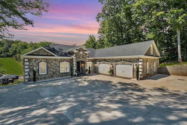 view of front of home featuring a garage, concrete driveway, and roof with shingles