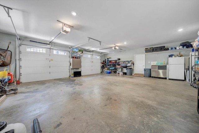 garage featuring a garage door opener and freestanding refrigerator