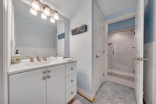 full bath with tile patterned flooring, wainscoting, a shower stall, and vanity