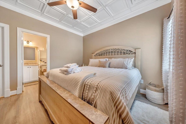 bedroom with light wood-type flooring, ensuite bath, an ornate ceiling, and baseboards