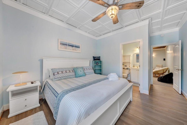 bedroom featuring a ceiling fan, wood finished floors, an ornate ceiling, and baseboards