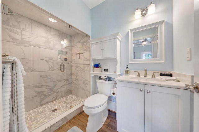 full bath featuring toilet, a stall shower, wood finished floors, and vanity