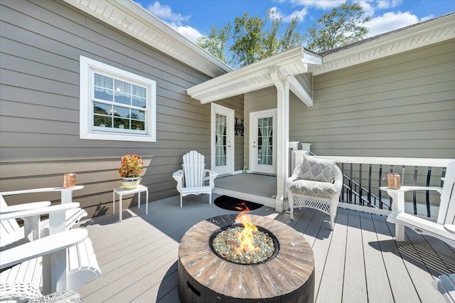 wooden terrace featuring an outdoor fire pit