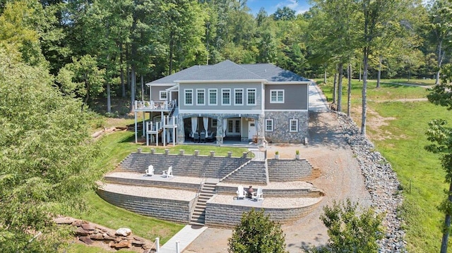 back of house with a patio area, stairs, and stone siding