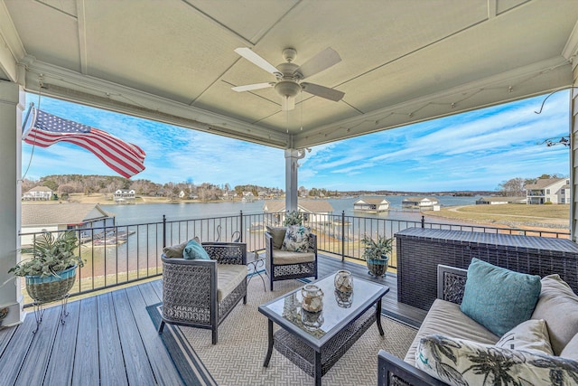 wooden deck with a water view, an outdoor living space, and a ceiling fan