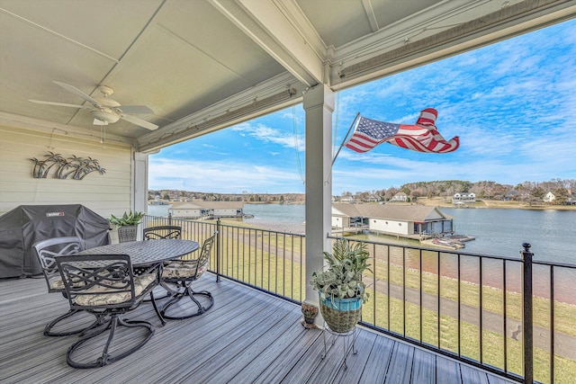 wooden terrace with ceiling fan, outdoor dining area, a water view, and a grill