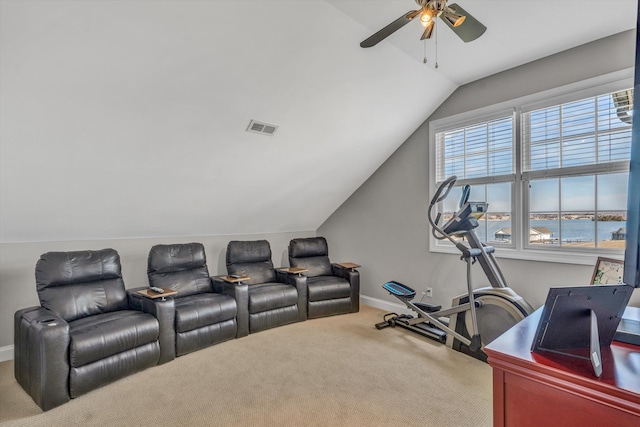 cinema room with carpet floors, visible vents, vaulted ceiling, ceiling fan, and baseboards