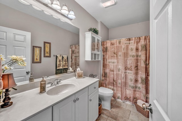 bathroom featuring toilet, curtained shower, and vanity