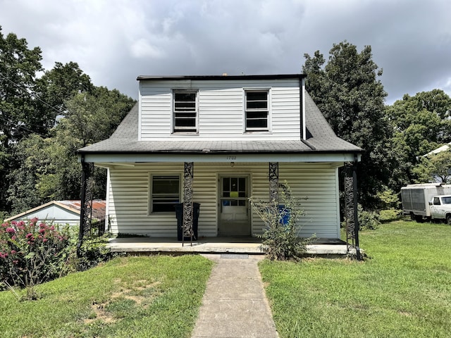 bungalow-style home featuring covered porch, roof with shingles, and a front yard