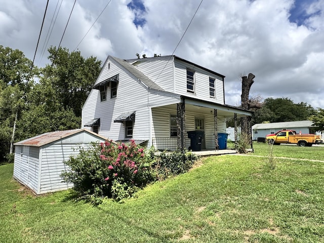 view of side of home with a lawn and an outdoor structure