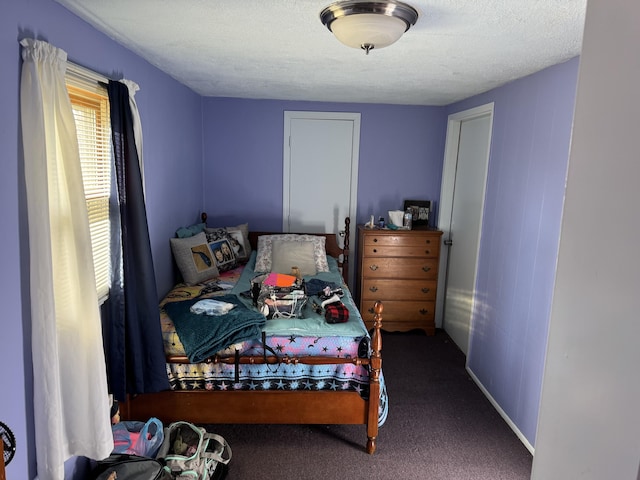 bedroom featuring a textured ceiling and carpet