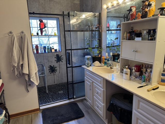 full bathroom featuring a stall shower, vanity, and wood finished floors