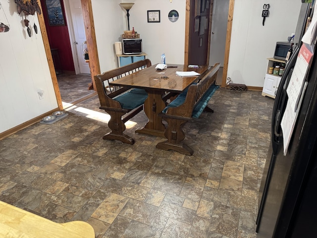 dining space featuring stone finish floor and baseboards