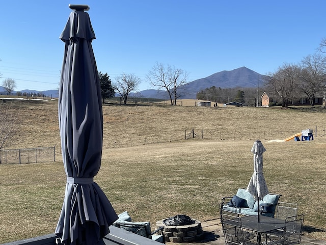 view of yard with a rural view, a mountain view, and fence