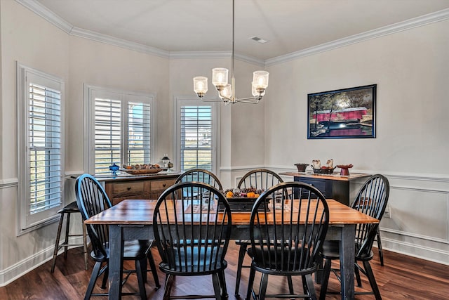 dining area featuring ornamental molding, dark wood finished floors, and an inviting chandelier